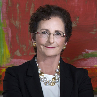 Nancy Nasher is facing forward and smiling. She has short brown hair and wears glasses.