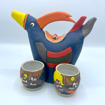 Clay sculpture of a bird that is a tea pot.