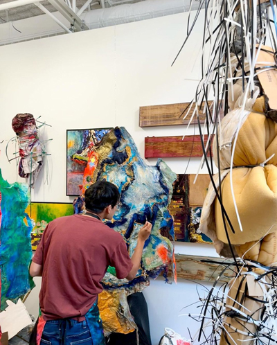 Narong Tintamusik is working on a painting in his studio.